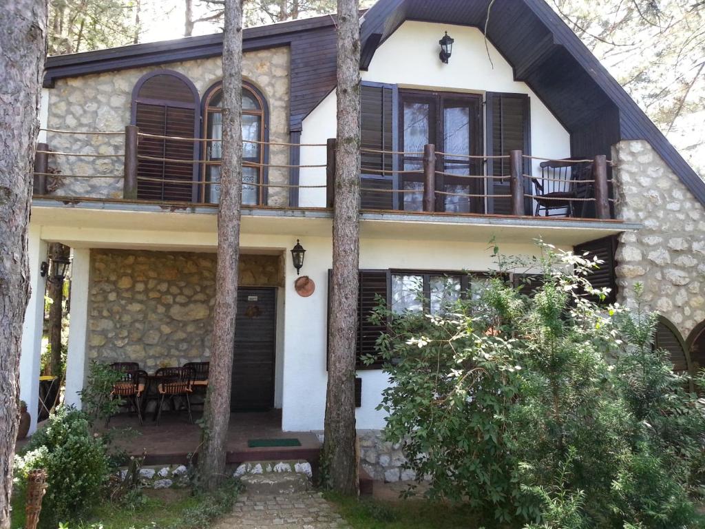 a house in the woods with a balcony at Guesthouse Bajka in Vinci