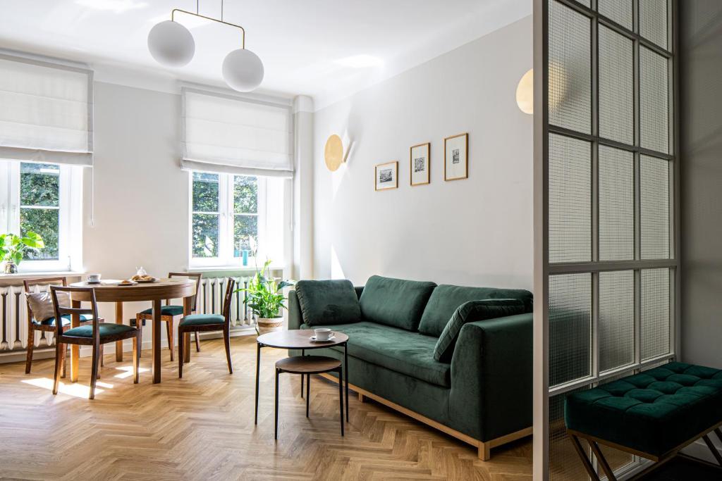 un soggiorno con divano verde e tavolo di Warsaw Heritage Apartment a Varsavia