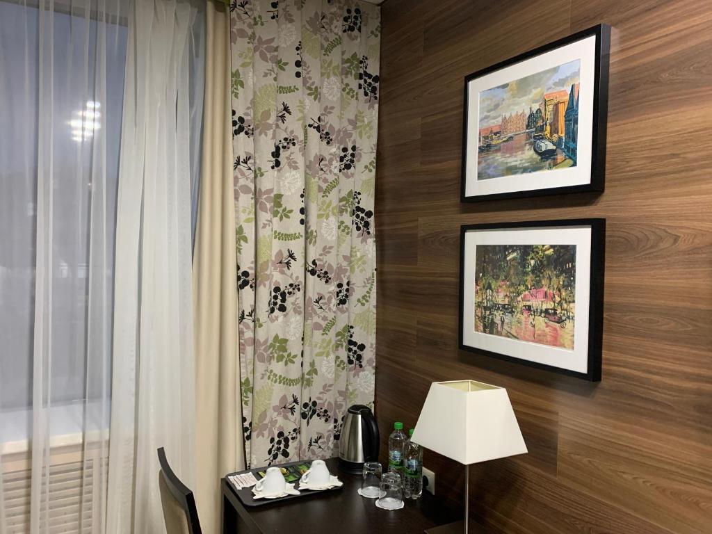 a room with a table with a lamp and a window at Business Hotel Diplomat in Nizhny Novgorod