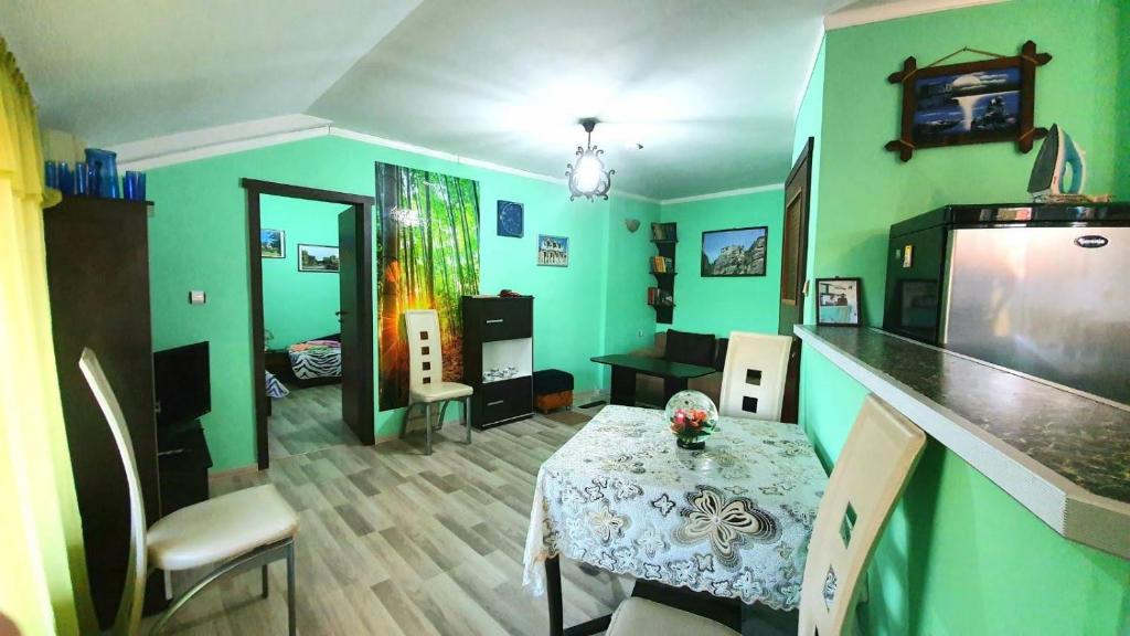 a living room with a table and green walls at Апартамент за гости"Вълчанови" in Elkhovo