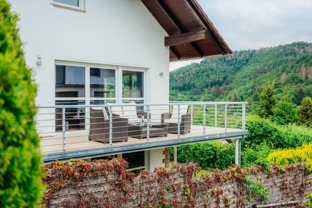 une maison avec une terrasse munie de chaises dans l'établissement FeWoLa, à Wieda