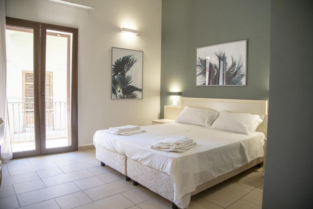 a bedroom with a white bed with two towels on it at Le Plejadi in Castellammare del Golfo