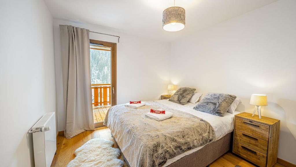 une chambre blanche avec un lit et une fenêtre dans l'établissement Les Freinets - Apt C101 - Châtel, à Châtel