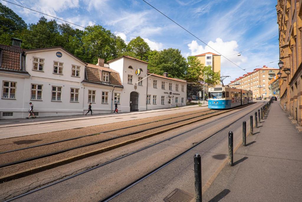 哥特堡的住宿－司提閣博格司麗登STF旅館，城市街道上的蓝色电车,有建筑