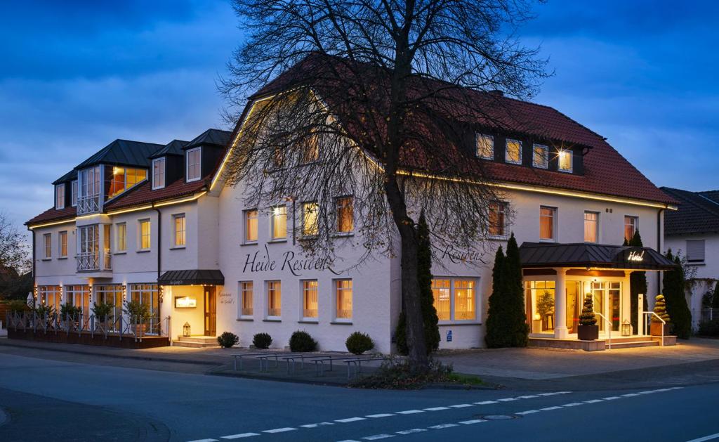 duży biały budynek po stronie ulicy w obiekcie Hotel Heide Residenz w mieście Paderborn