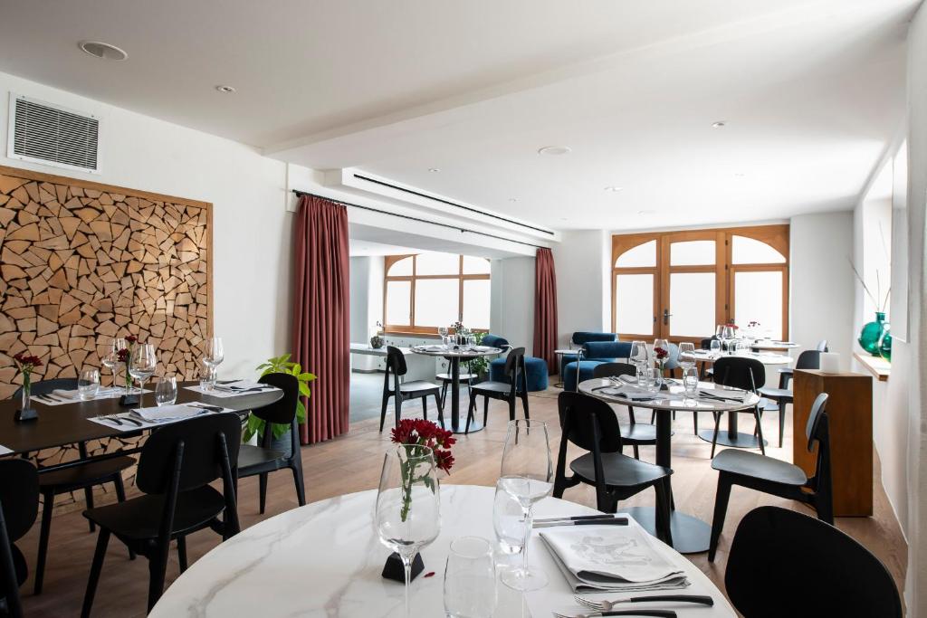 una sala da pranzo con tavoli, sedie e finestre di Le Sauvage a Friburgo