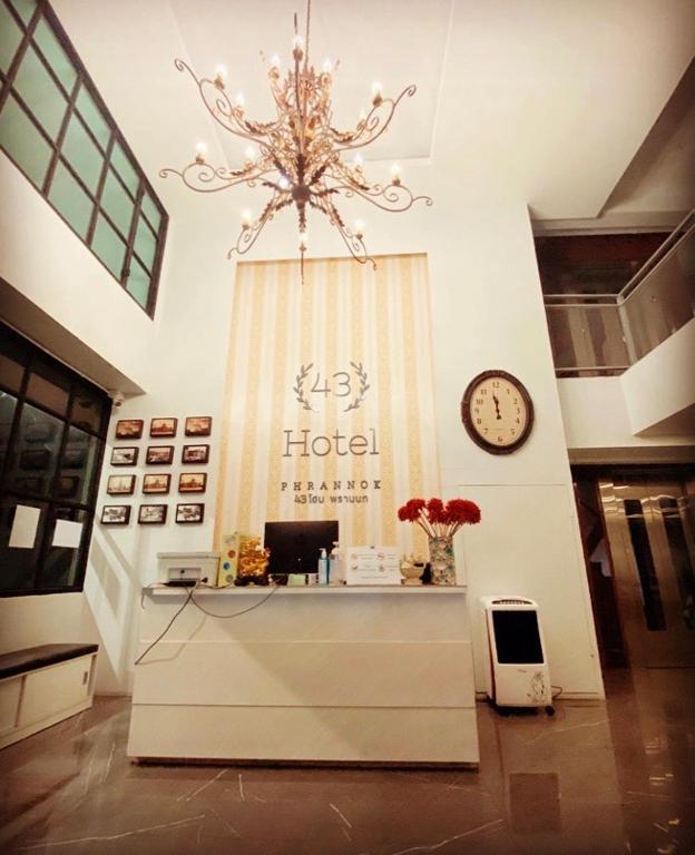 A reception desk beneath a large chandelier in the hotel’s double-height lobby.