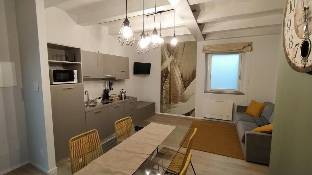 a kitchen and a living room with a table and a couch at Appartamenti il borgo girasole in Busca