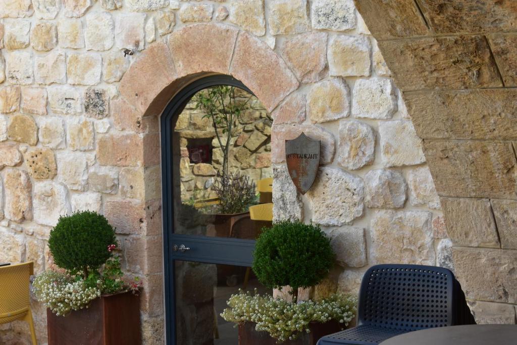 Chateau du Roi في Mi‘ilyā: جدار حجري مع باب مع نافذة والنباتات