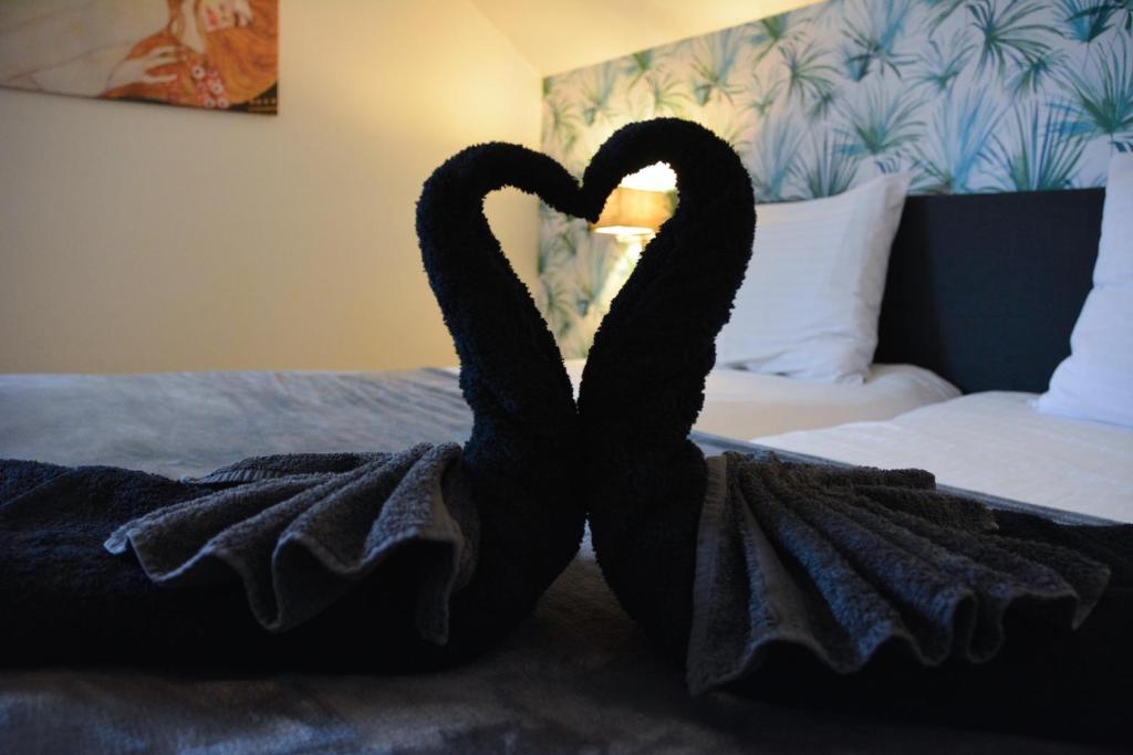 a pair of black swans sitting on a bed at B&B Afrodite in Zonnebeke