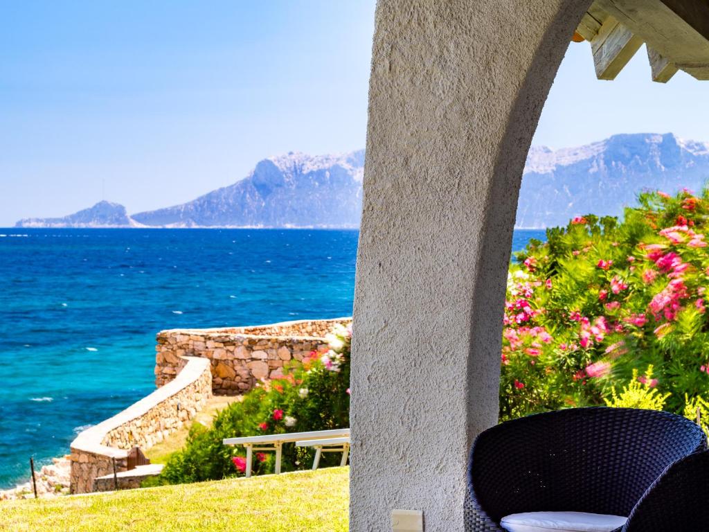 a room with a view of the ocean and mountains at Villa Miriam - Klodge in Olbia