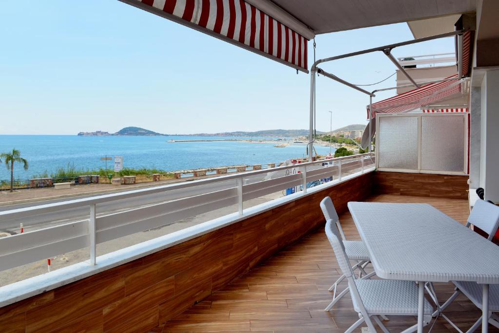 balkon ze stołem i krzesłami oraz widokiem na ocean w obiekcie Bellavista Formia w mieście Formia