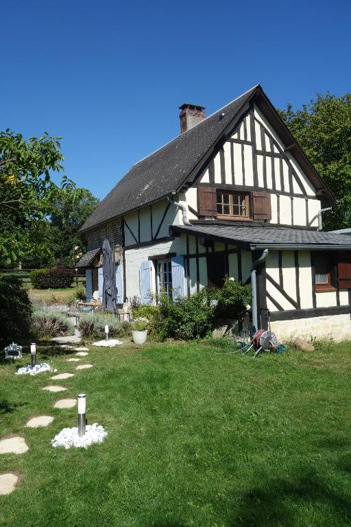 una gran casa blanca y negra con un patio en Le cottage du Coudray, gîte avec chalet sauna, 