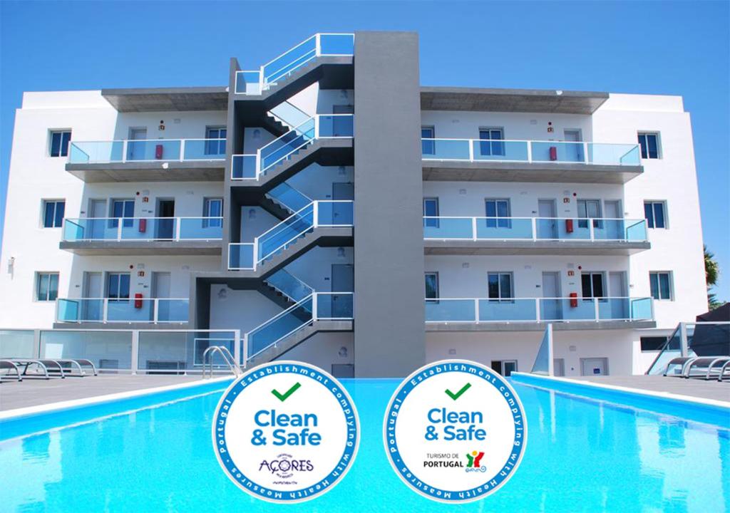 a building with a swimming pool in front of a building at Whalesbay Hotel Apartamentos in Capelas