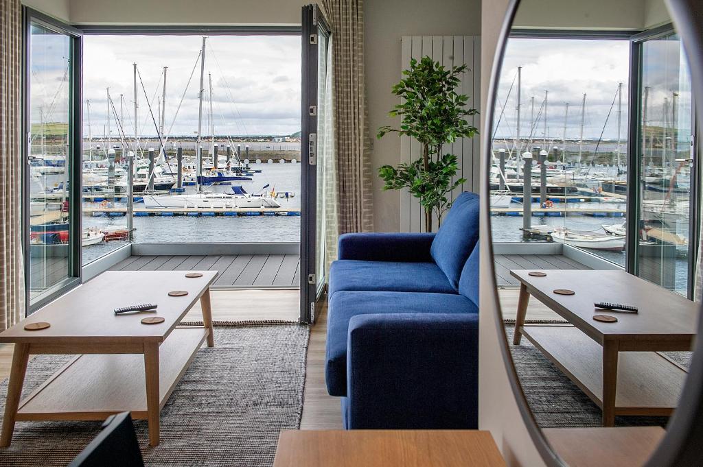 a living room with a blue couch and a view of a harbor at The Salt Lodge in Troon