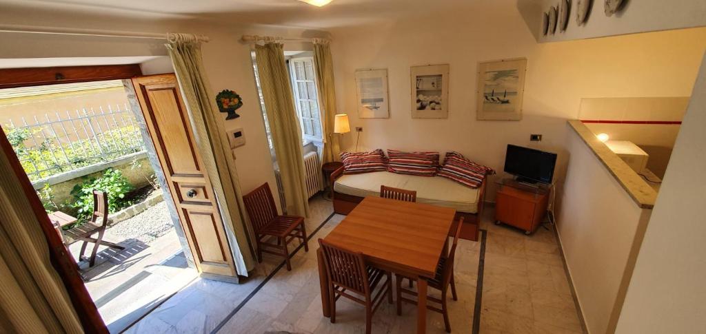 ein kleines Wohnzimmer mit einem Tisch und einem Bett in der Unterkunft LE ORCHIDEE già Lancillotto in Levanto