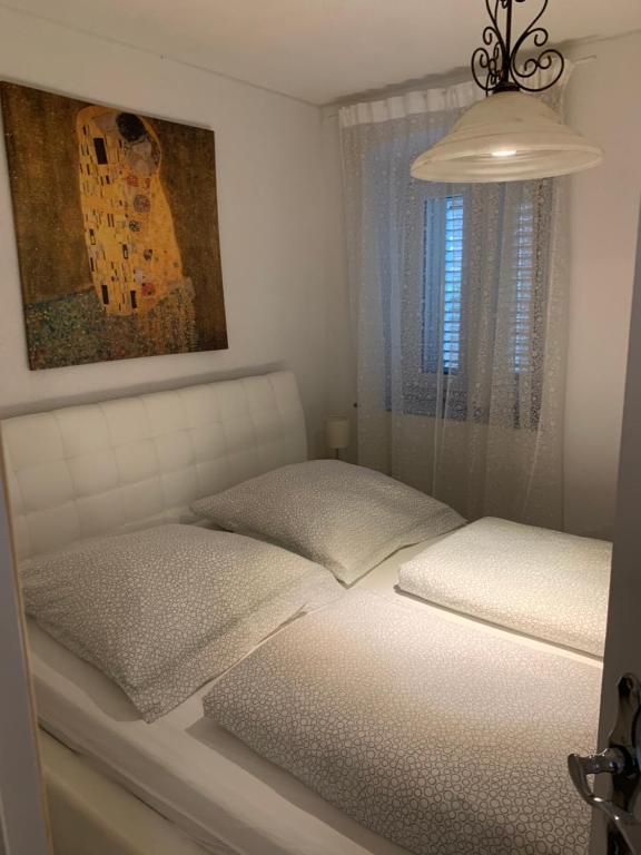 ein Schlafzimmer mit einem weißen Bett und einem Fenster in der Unterkunft Apartman Annamaria in Cres