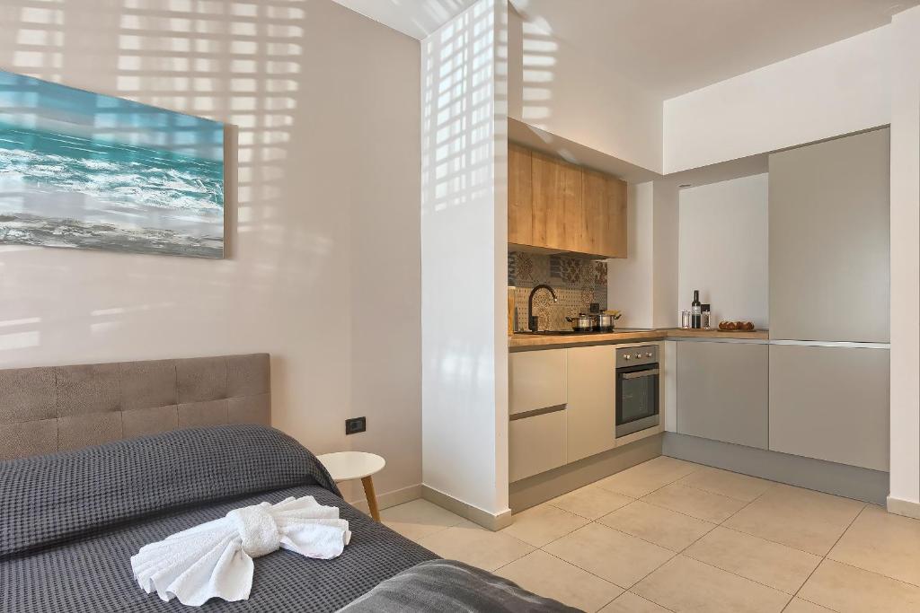 1 Schlafzimmer mit einem Bett und einer Küche in der Unterkunft Adriatic Apartments Fažana in Fažana