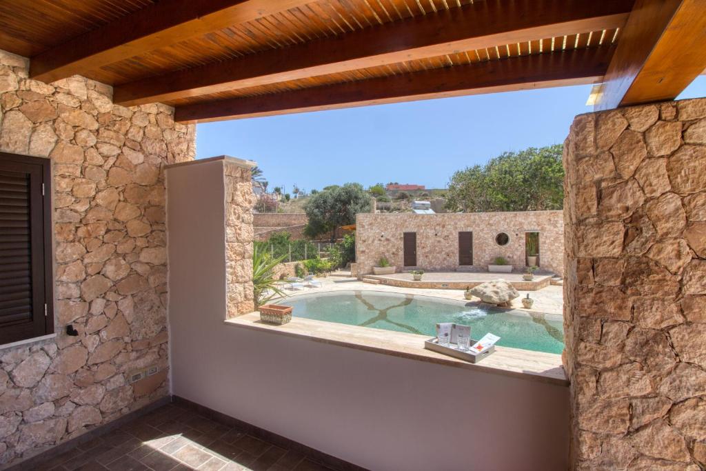 an external view of a stone house with a swimming pool at Residence Il Corallo - Guitgia in Lampedusa
