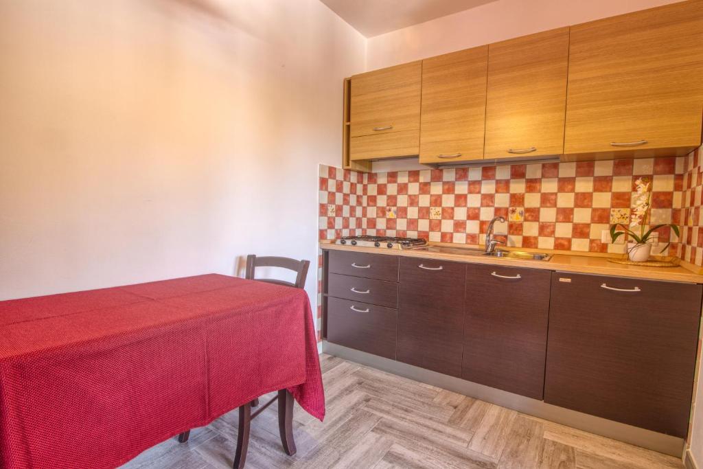 a kitchen with a table with a red table cloth at Residence Il Corallo - Guitgia in Lampedusa