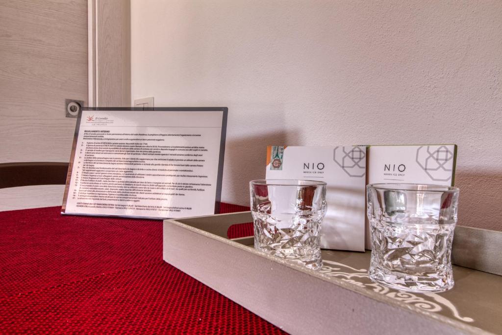two glasses sitting on a table with a box at Residence Il Corallo - Guitgia in Lampedusa