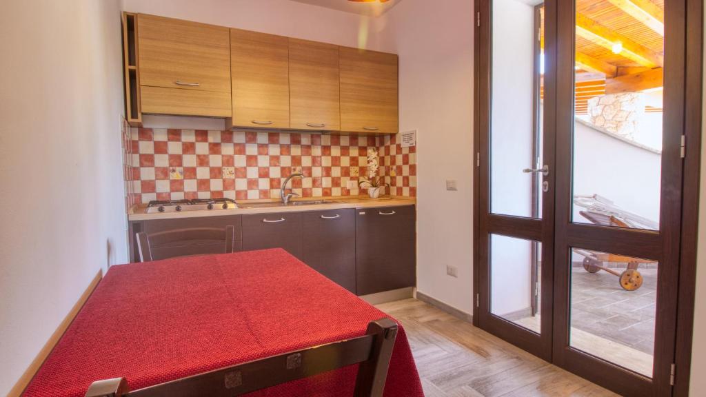 a kitchen with a red table with a red counter top at Residence Il Corallo - Guitgia in Lampedusa
