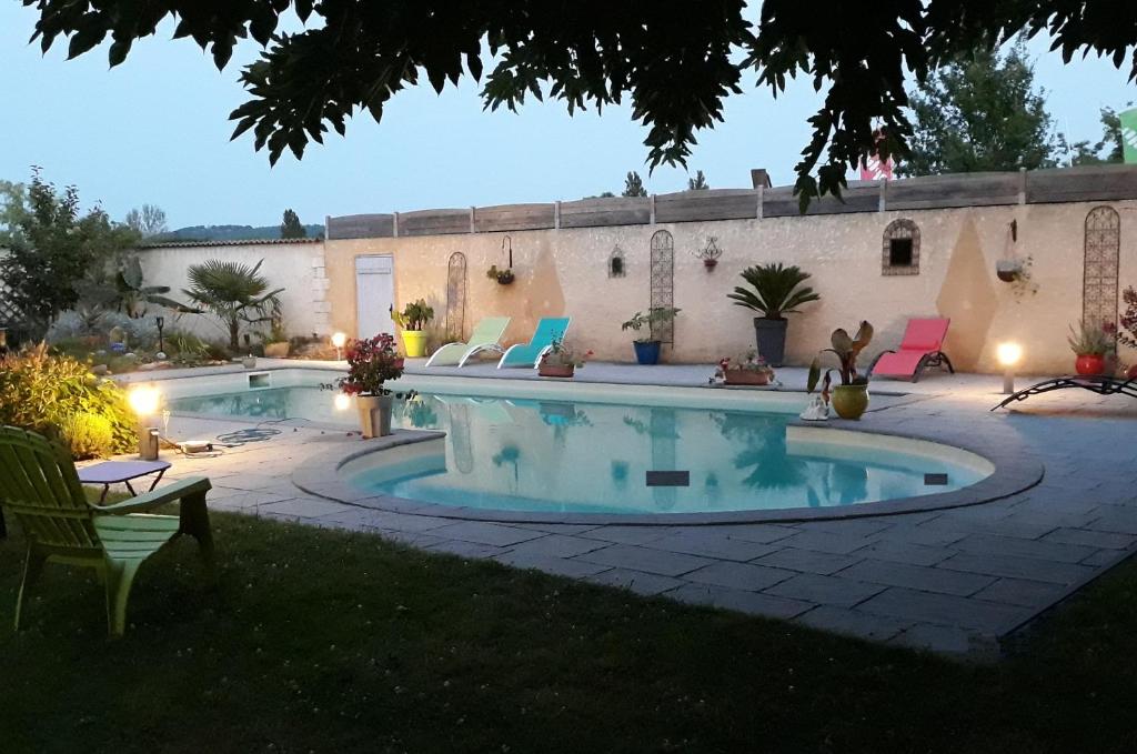ein Pool in einem Garten mit Stühlen um ihn herum in der Unterkunft Le Clos de la Salamandre in Duravel