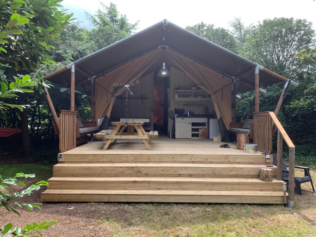 une tente avec des escaliers, une table et une cuisine dans l'établissement Glamping Wolfskuilen, à Lieren