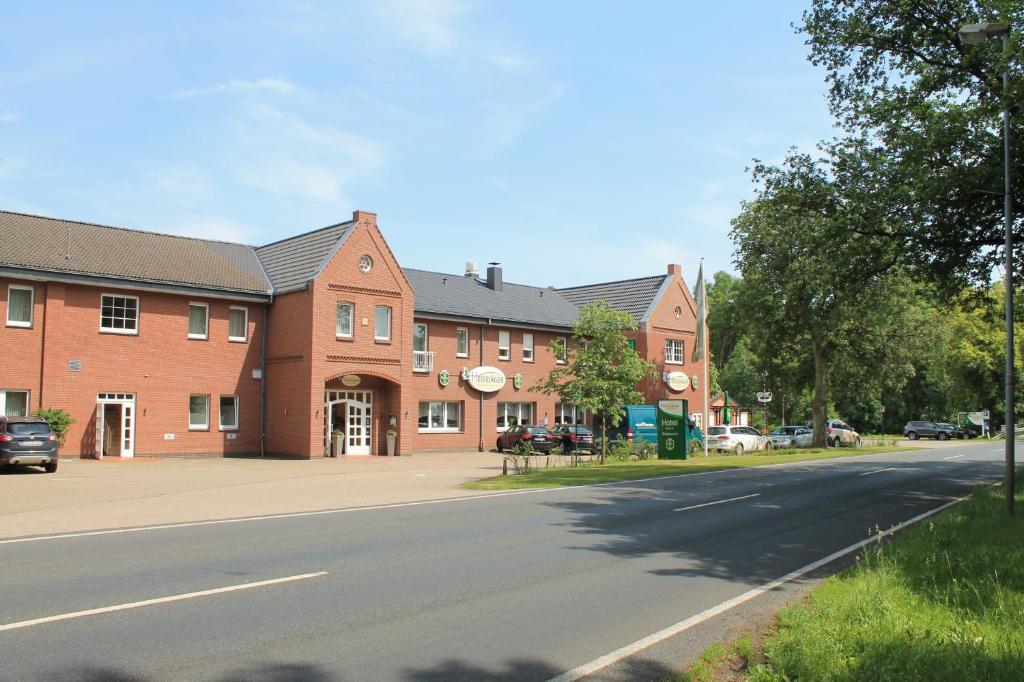 a large brick building on the side of a street at Kräuterhotel & Restaurant Heidejäger in Mulmshorn