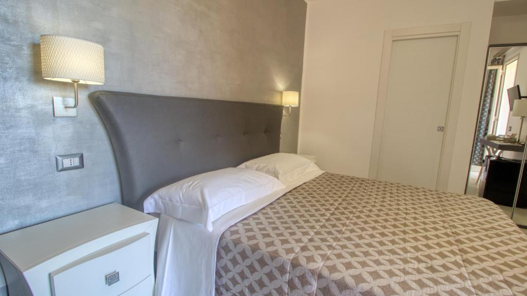 a bedroom with a bed with a large headboard at Residence Il Corallo - Guitgia in Lampedusa