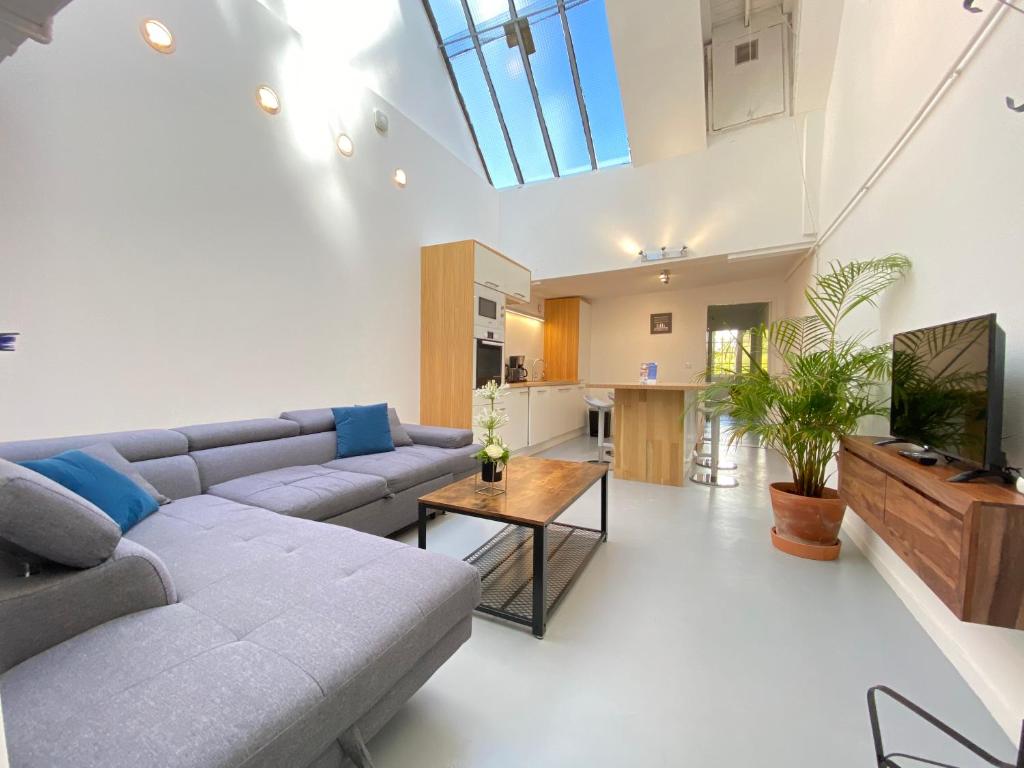 a living room with a couch and a table at Boutique Hôtel Un Appart en Ville in Bayonne