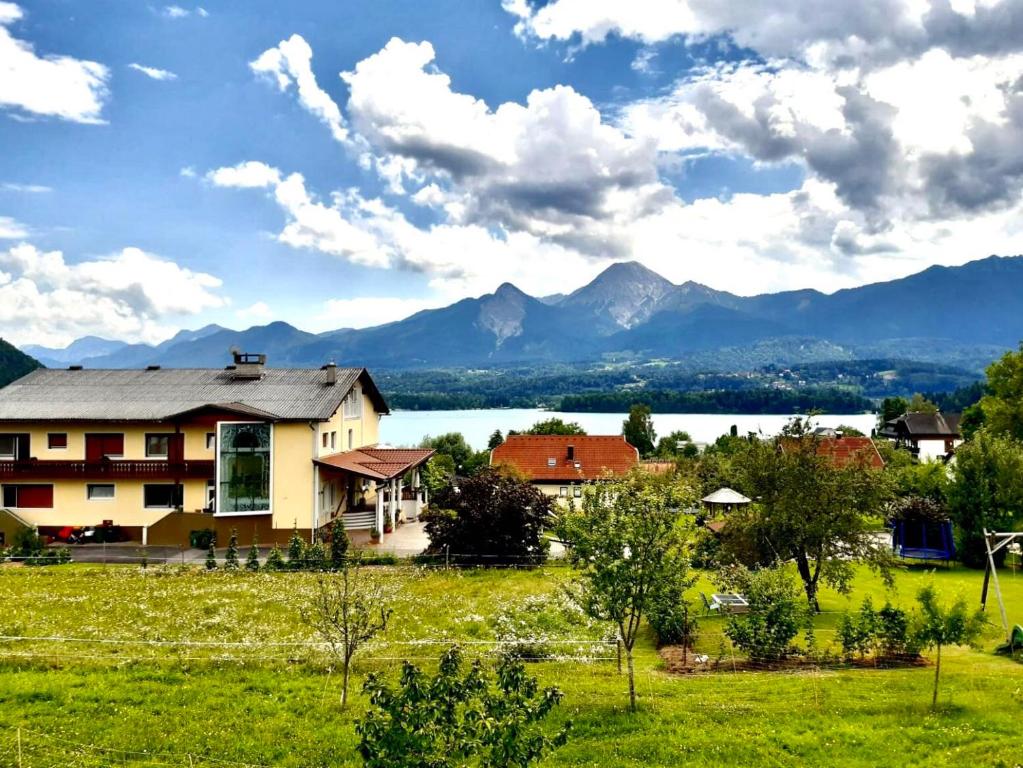 uma casa num campo com um lago e montanhas em Lake View Drobollach em Villach
