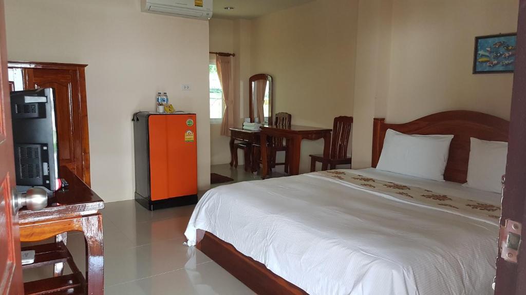 a bedroom with a bed and a tv in it at Ratchaphruek Resort in Lop Buri