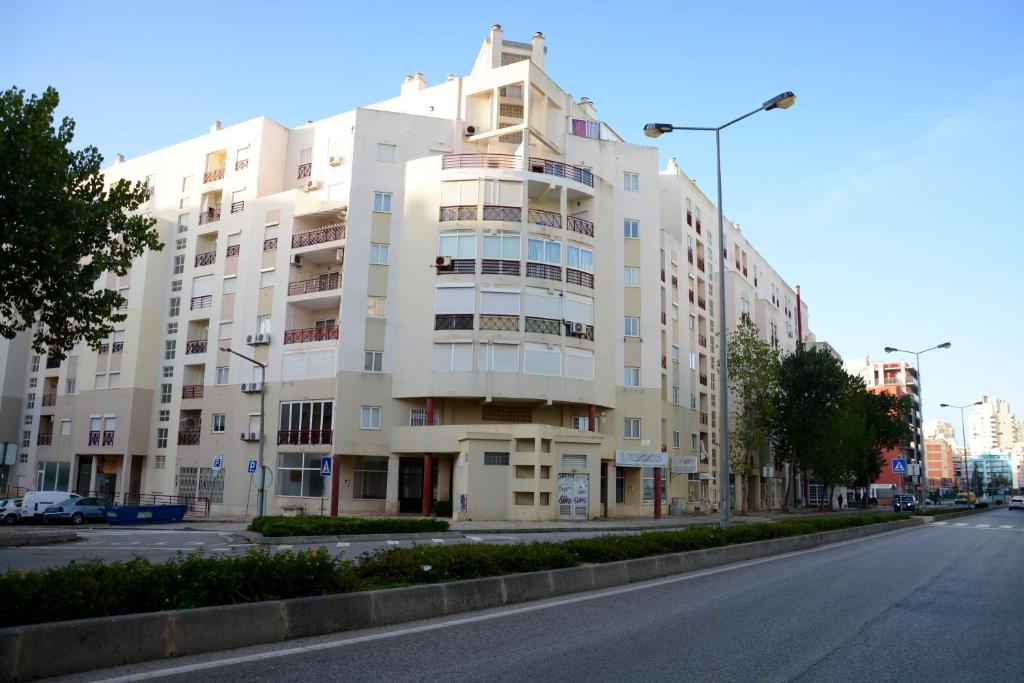 a large white building on the side of a street at Casa Canoa B in Armação de Pêra