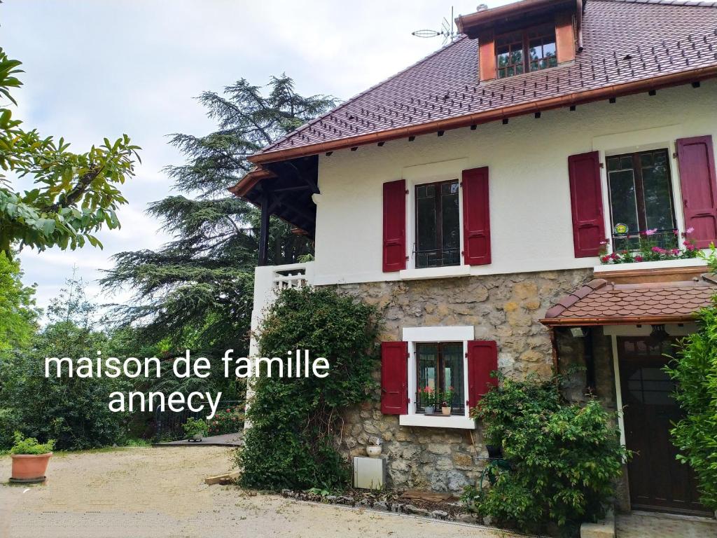 una casa con persianas rojas y las palabras misión hacer emergencia familiar en VILLA SERANDITE maison de famille, en Annecy