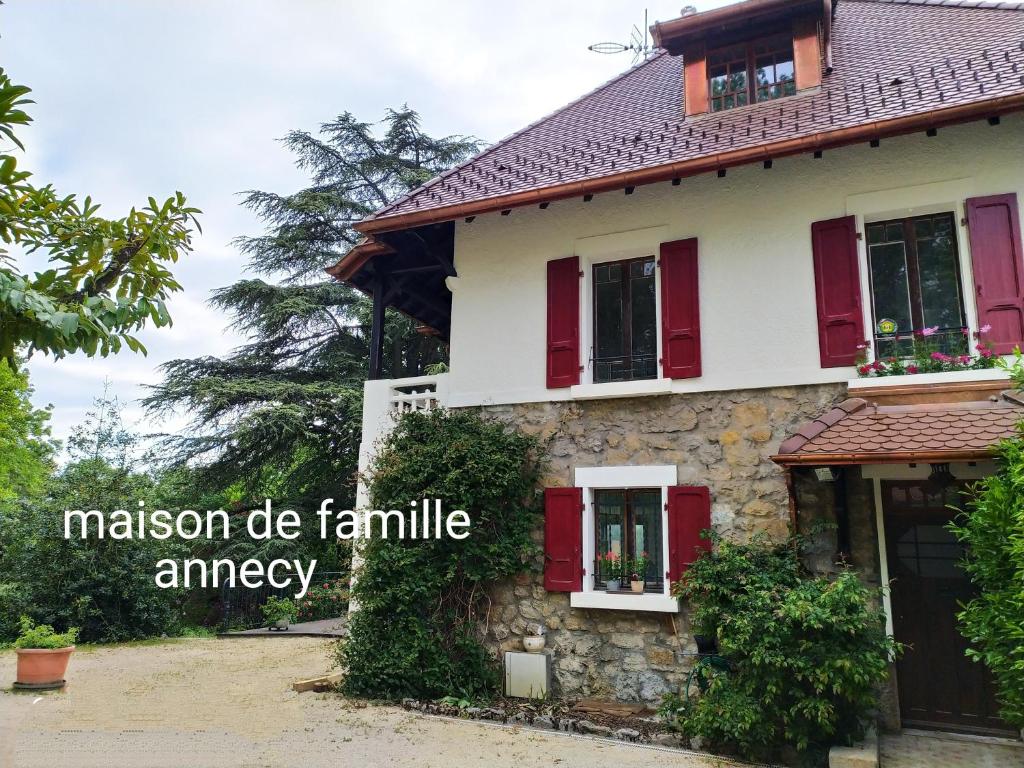 a house with red shutters and the words mission do family emergency at VILLA SERANDITE maison de famille in Annecy