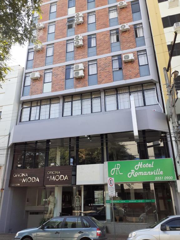 a building with cars parked in front of it at Hotel Romanville in Chapecó