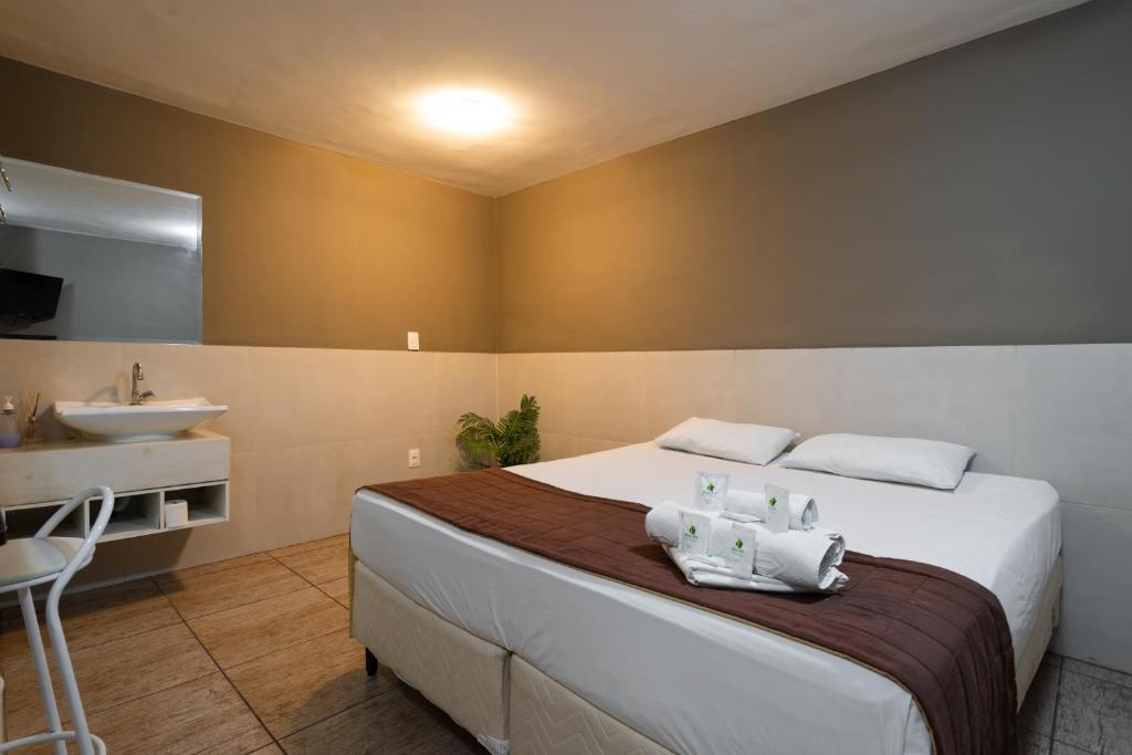 a bedroom with a large bed and a sink at Hotel BH Inn Palmares - By UP Hotel - Acesso Cristiano Machado in Belo Horizonte