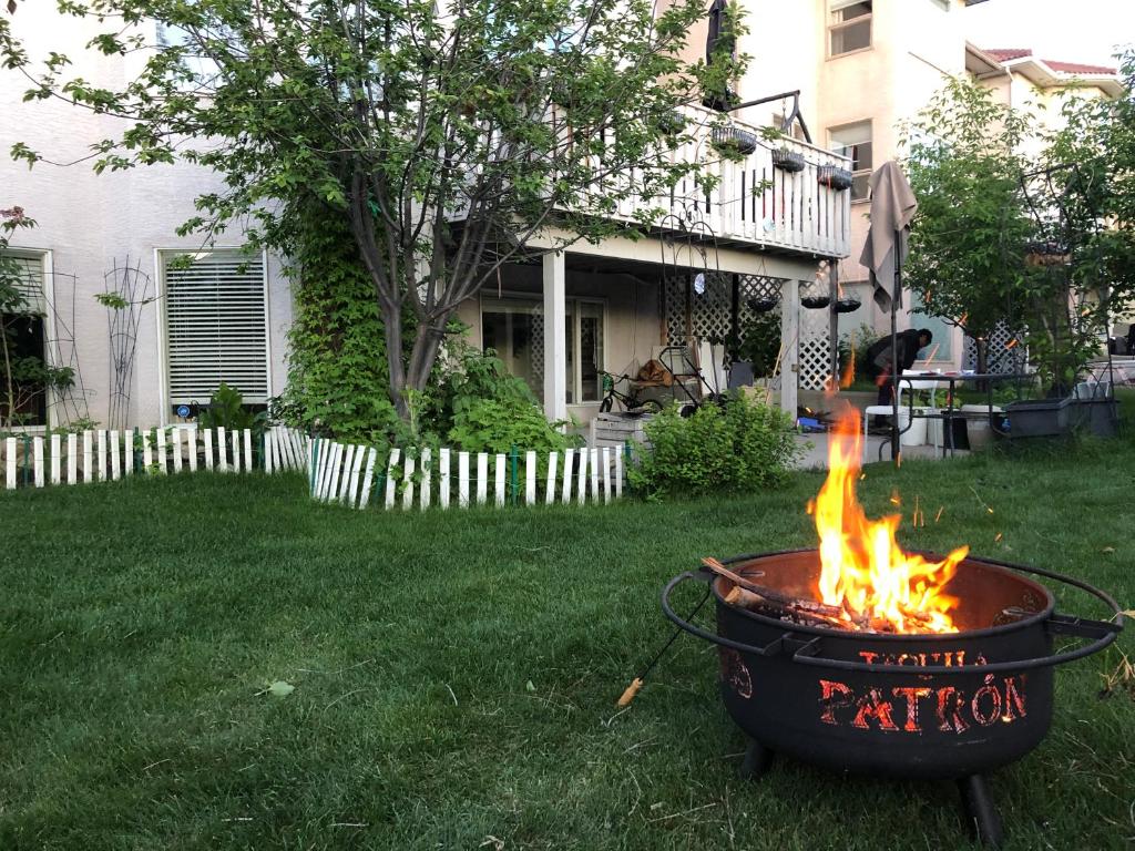 a barbecue grill with fire in a yard at Hamptons Rose garden family! in Calgary