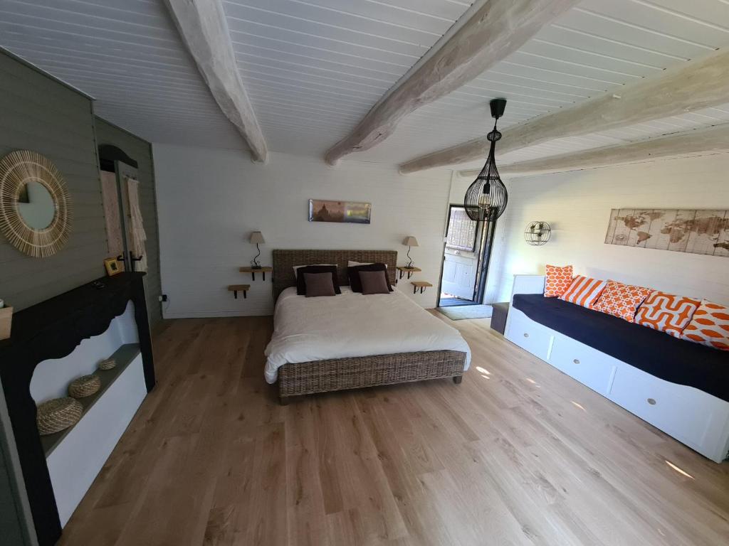 een slaapkamer met een bed en een bank bij Shanti Nilayam in Frayssines