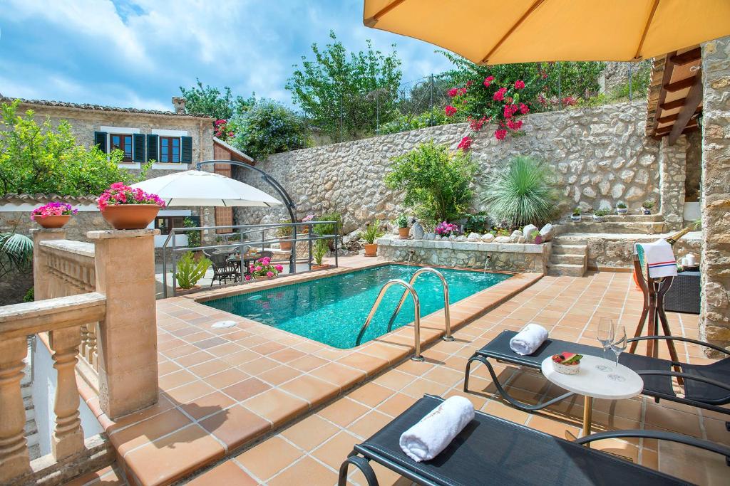 - une piscine avec une terrasse et un parasol dans l'établissement Petit Caimari - Turismo de interior, à Caimari