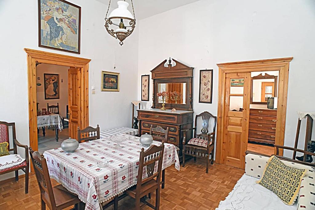 ein Esszimmer mit einem Tisch und einem Klavier in der Unterkunft Fabrica home in Apérathos