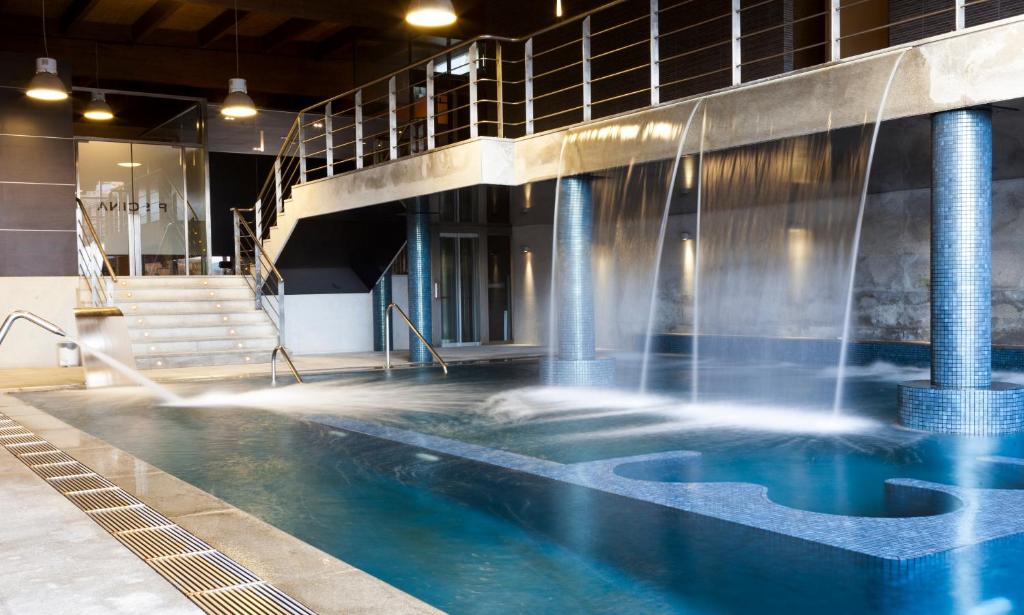 una piscina con agua saliendo de ella en Oca Vila de Allariz Hotel & Spa, en Allariz