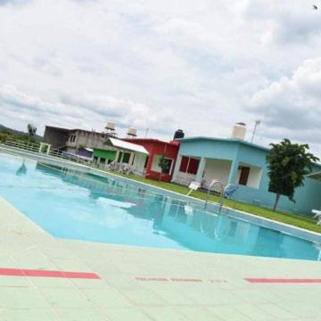 ein großes Schwimmbad mit Häusern im Hintergrund in der Unterkunft Hotel gallego in Campeche