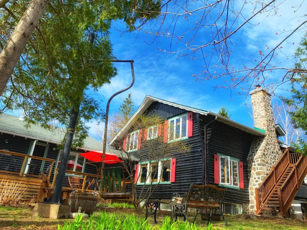 an old house with red shutters on it at Auberge Le Lupin-Self Check-in in Mont-Tremblant