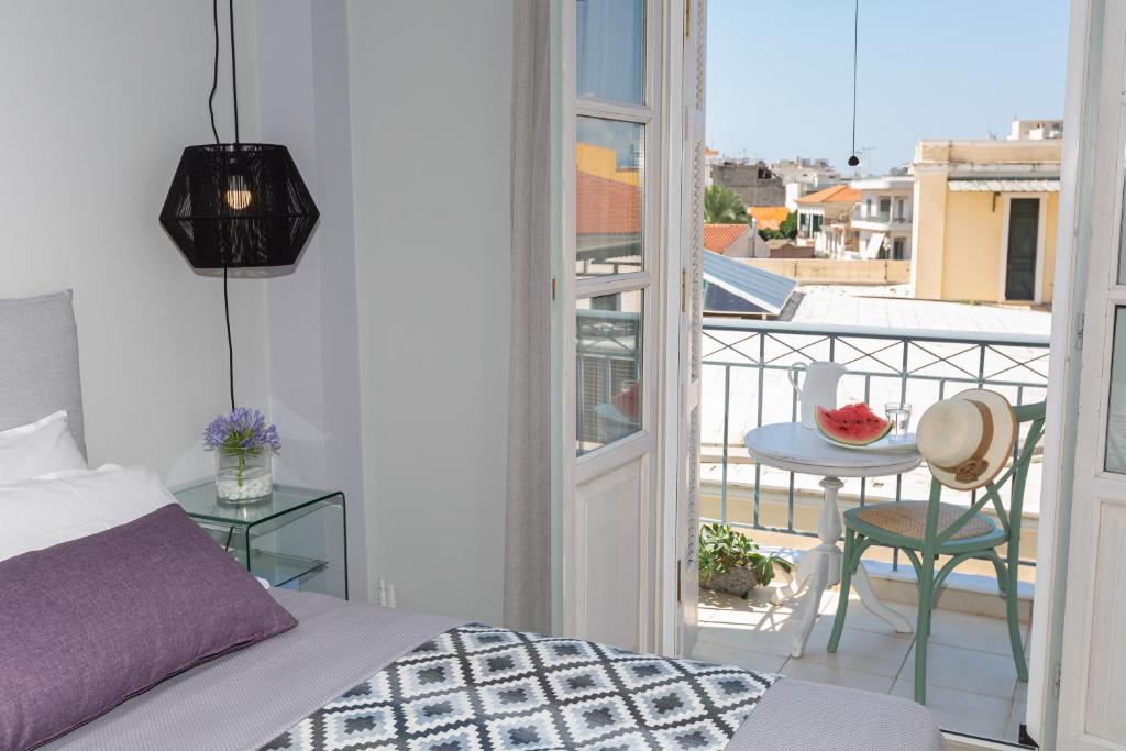 a bedroom with a bed and a balcony with a table at Jasmine - Apartment in Kalamata in Kalamata
