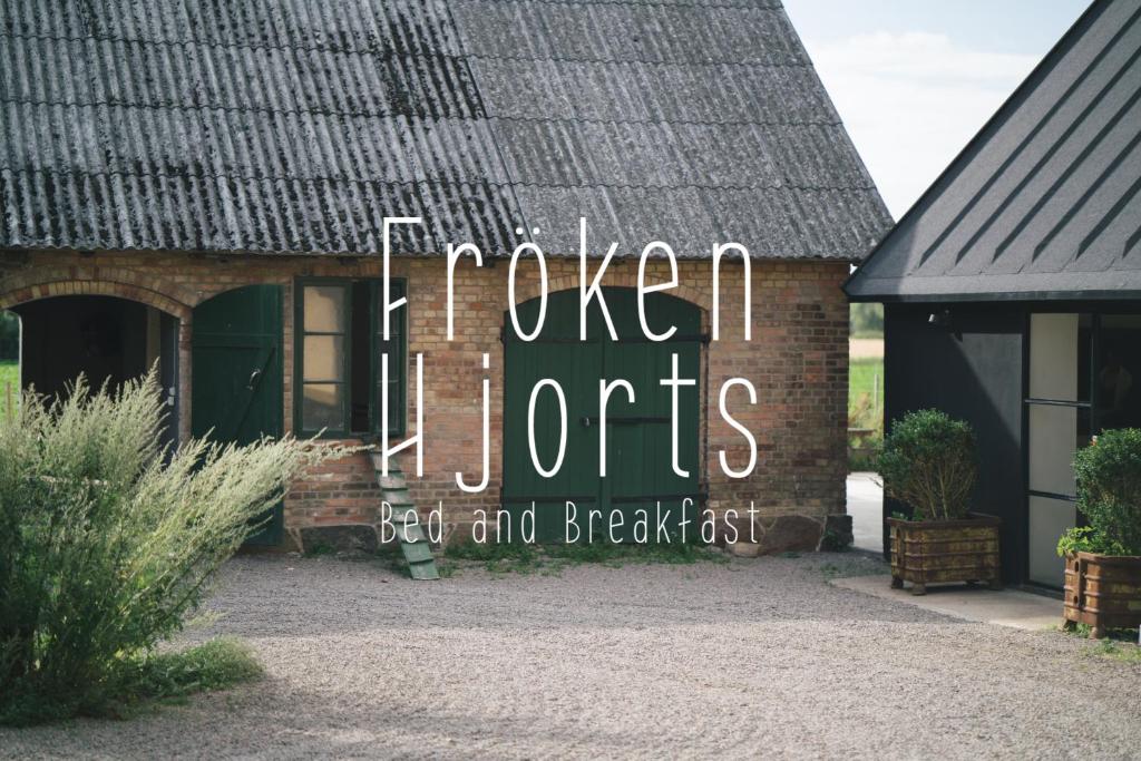 um sinal ao lado de uma casa de tijolos em Fröken Hjorts Bed and Breakfast em Höganäs