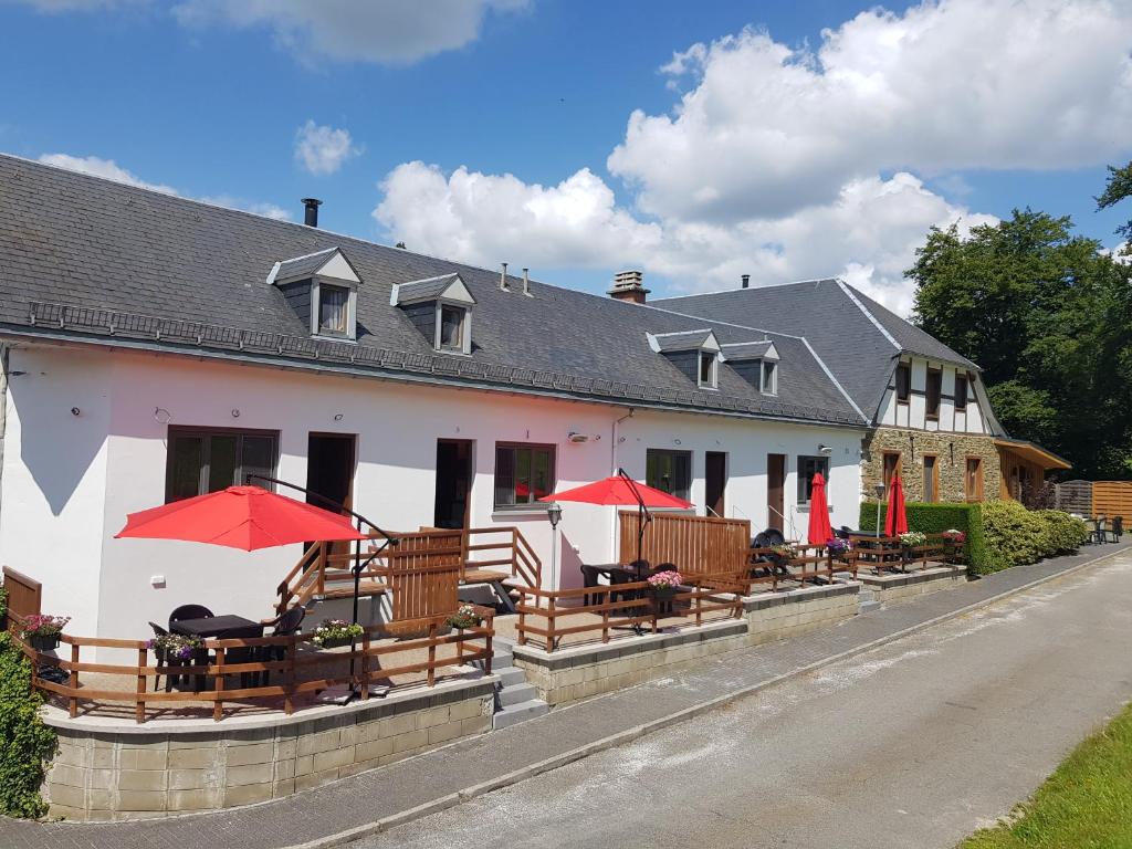 un edificio con bancos y sombrillas delante en Source d'Arimont, en Malmedy