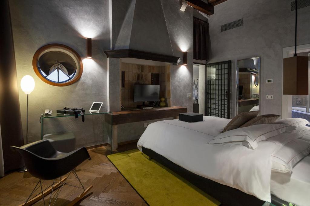 a room with a bed, a chair, and a lamp in it at Corte Di Gabriela in Venice
