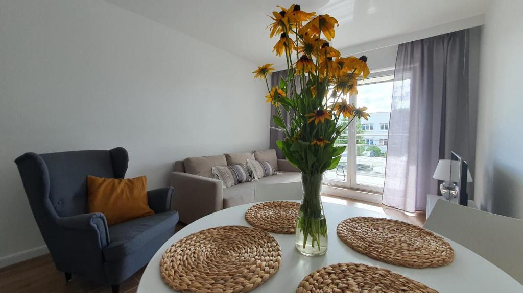 uma sala de estar com uma mesa com um vaso de flores em Apartament WILKASY (k. Giżycka) em Wilkasy